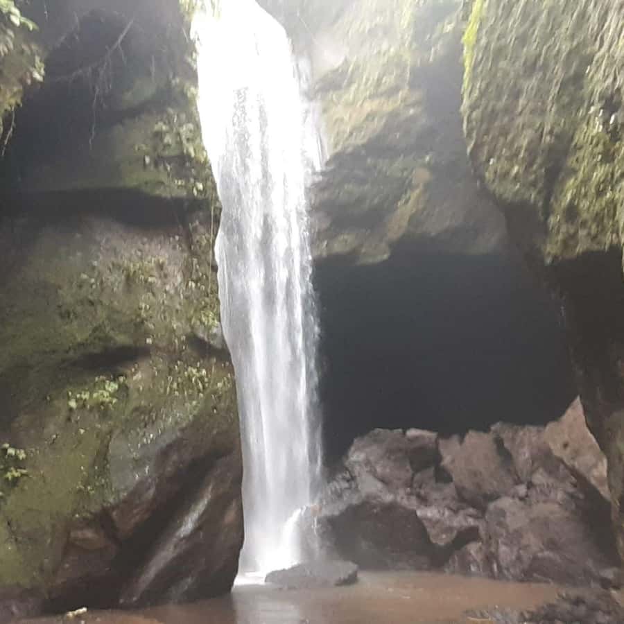 Bali: Penglipuran Village, Waterfall, and Night Market Tour - Goa Raja Waterfall, cliffs, and a shallow natural pool